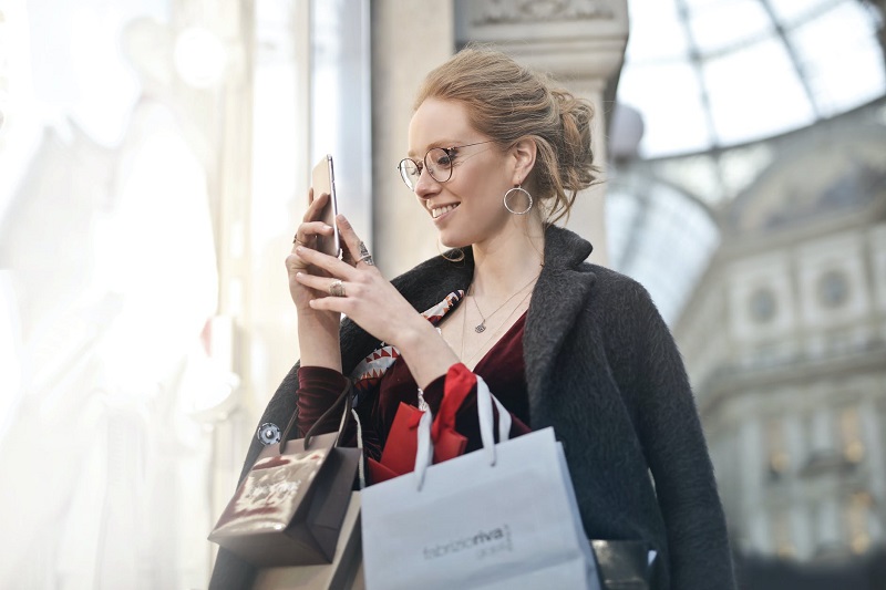 Mulher fazendo compras pelo celular em aplicativo de m-commerce